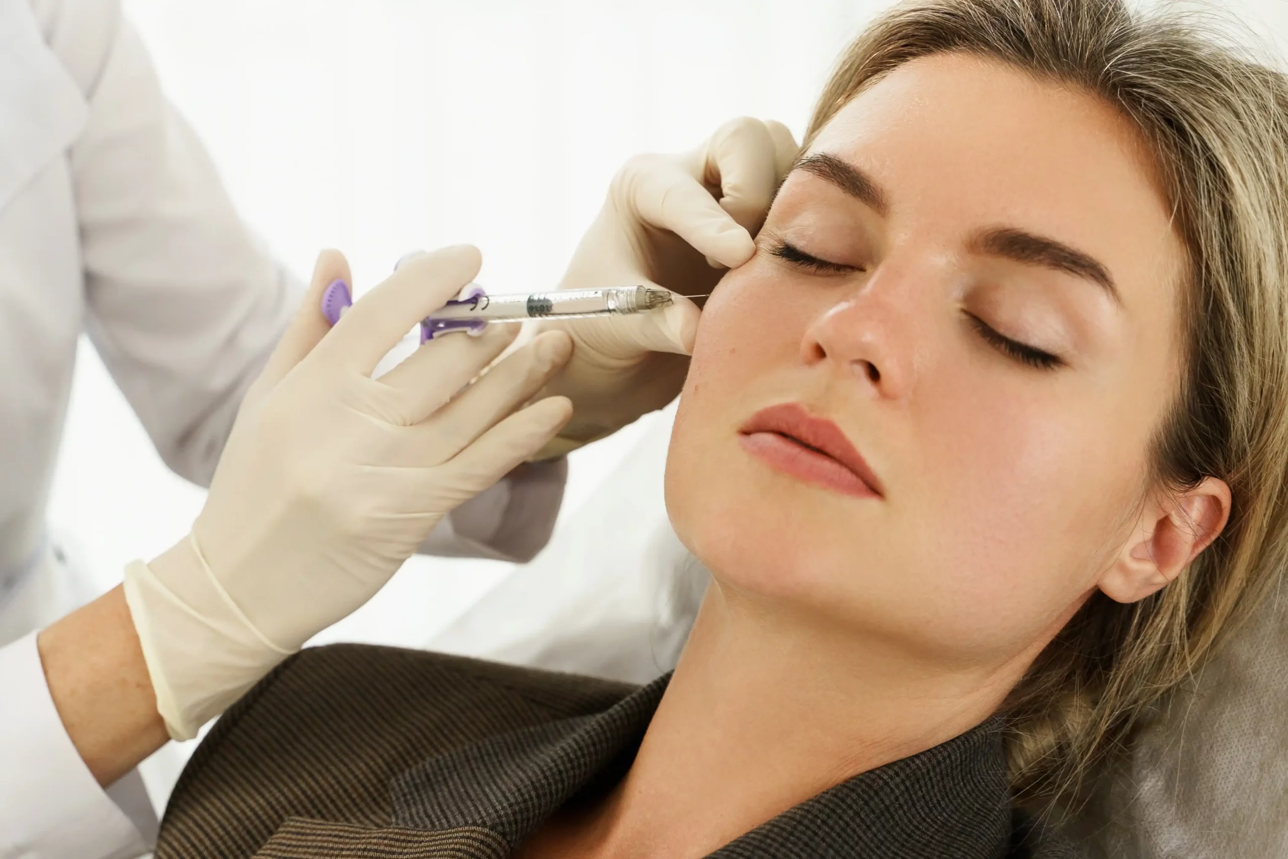 Professional aesthetician performing microneedling treatment on a relaxed female client to enhance skin rejuvenation at Skin Ritual in Gilbert, AZ